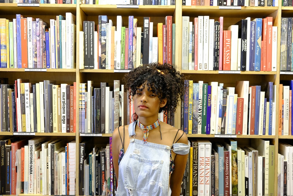A girl standing infront of books